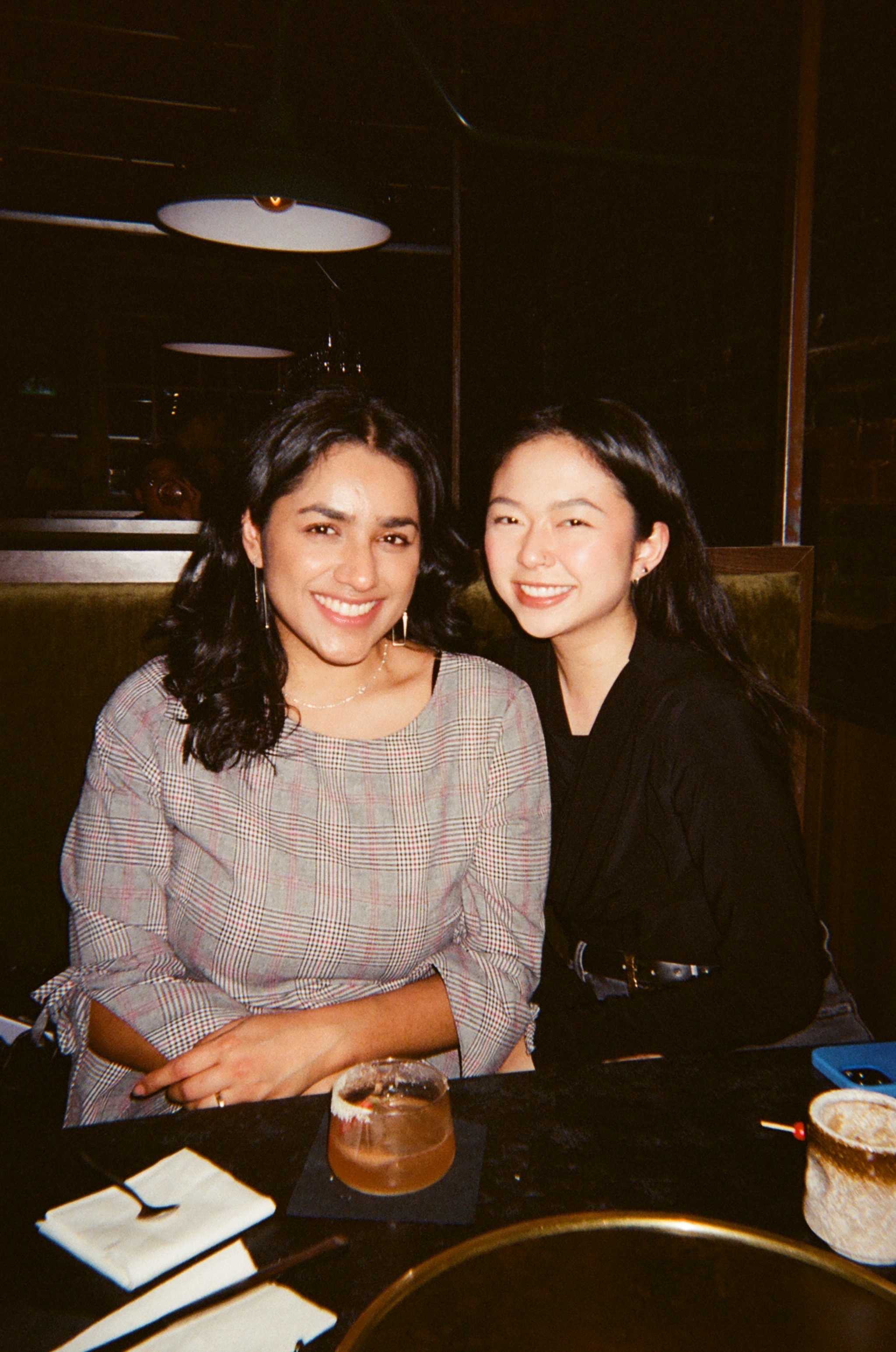 Portrait of a man with brown hair and glasses on a flat gray background.